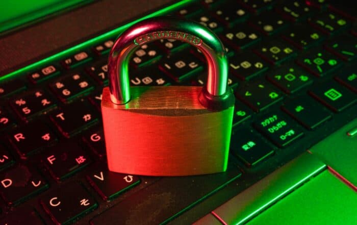 Laptop mit Vorhängeschloss symbolisiert IT-Sicherheit und Datenschutz.